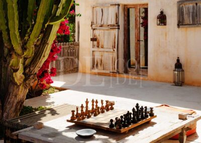 playing chess below the nature and flowers of the garden of villa casanita for rent in sant Francesc, formentera